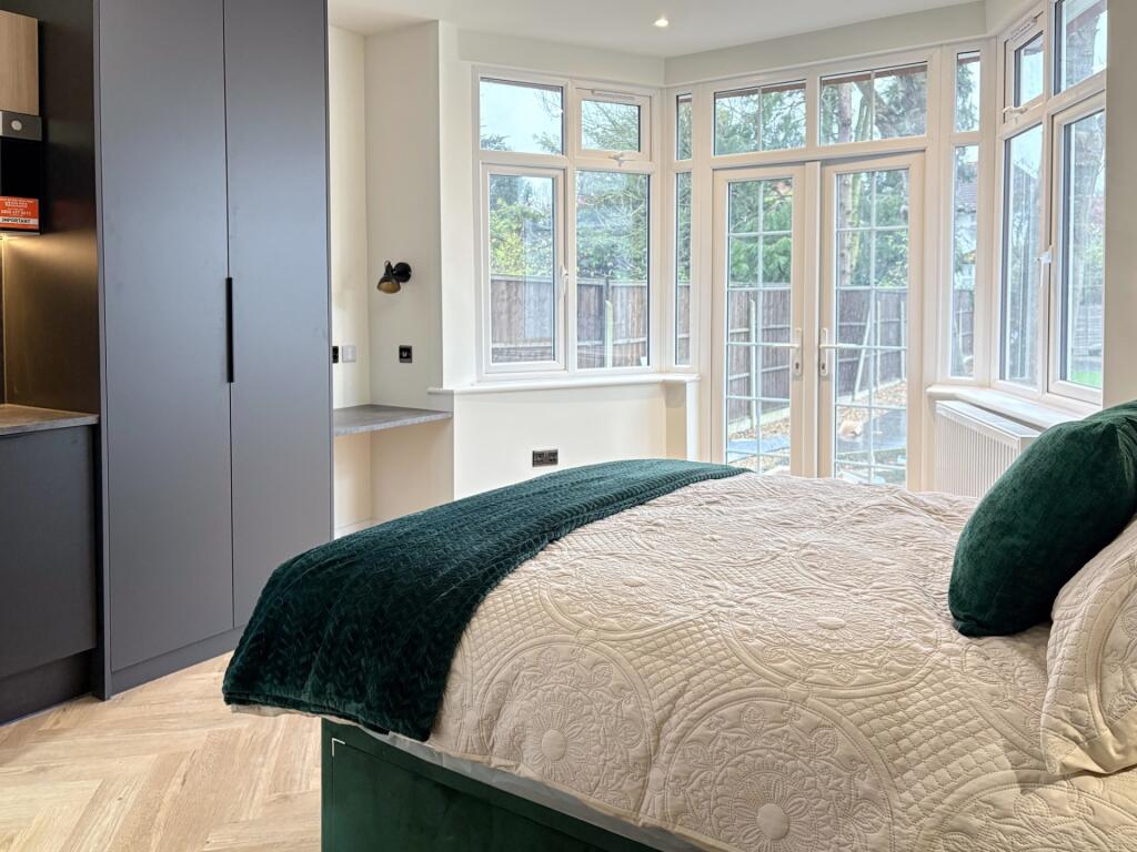 Bright double bedroom with a plush bed, large b...