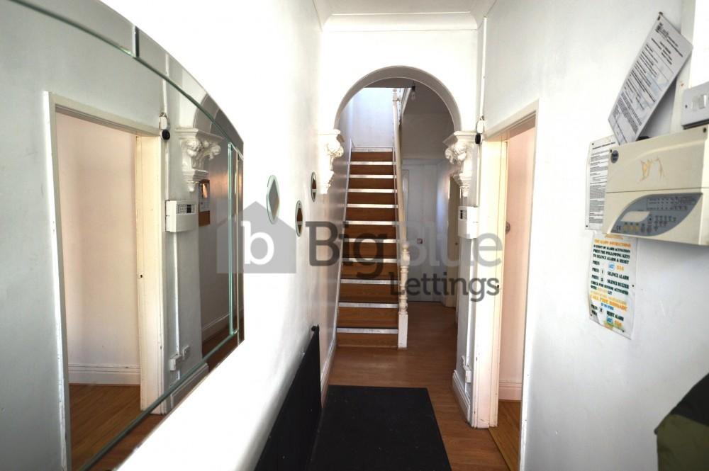 Bright and clean hallway featuring wooden floor...