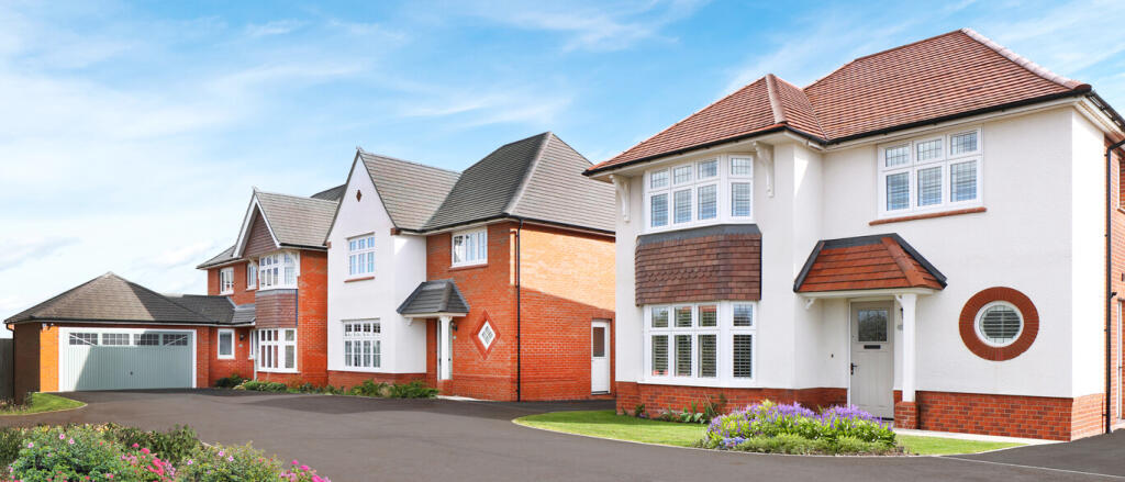 Modern residential houses with white walls, red brick accents, and pitched roofs, set against a blue