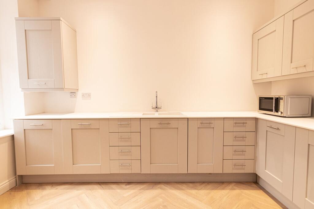 Bright and modern kitchen with ample storage ca...