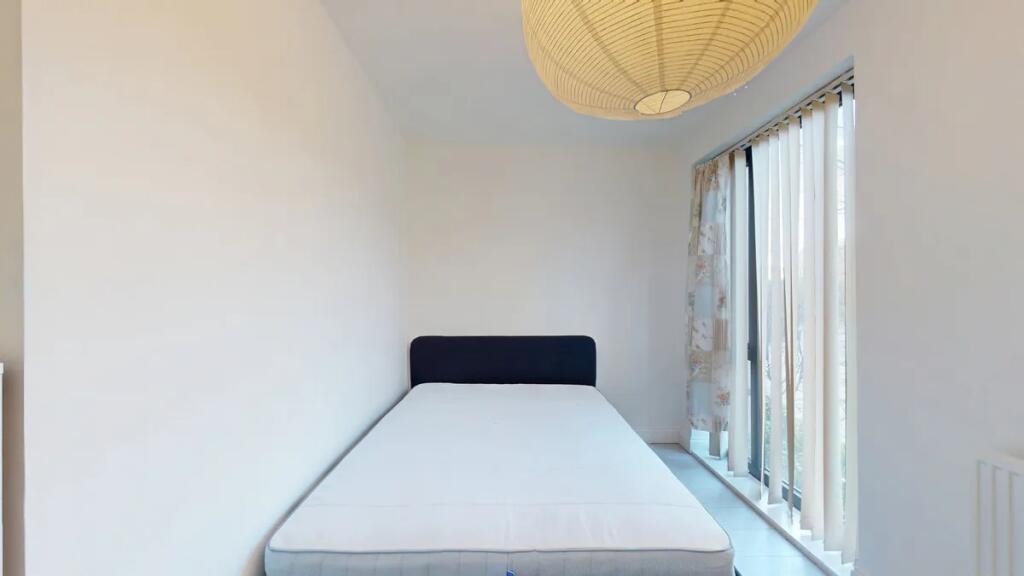 A bright and clean single bedroom featuring a m...