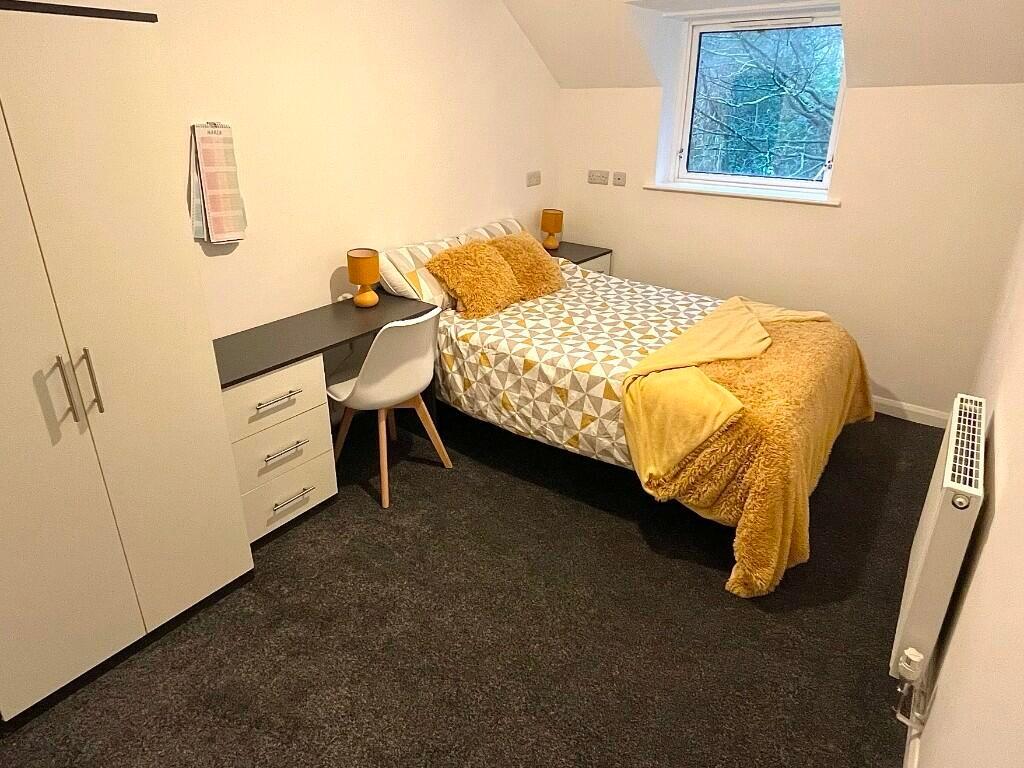 Cozy single bedroom featuring a comfortable bed...