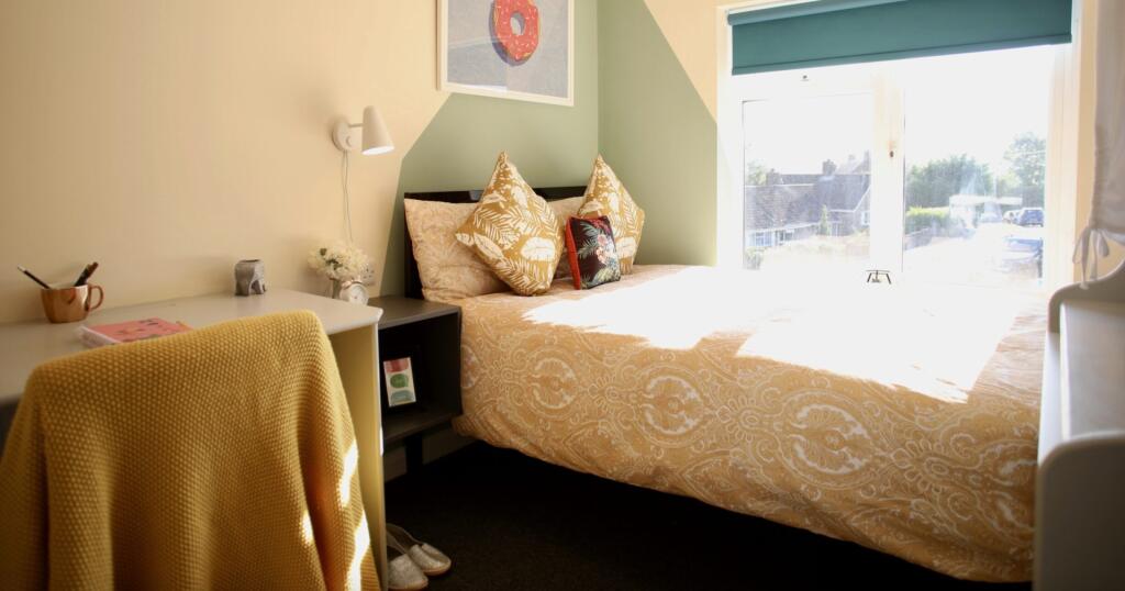 A cozy double bedroom featuring a large window ...