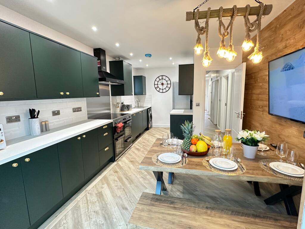 Modern kitchen featuring stylish cabinetry, amp...