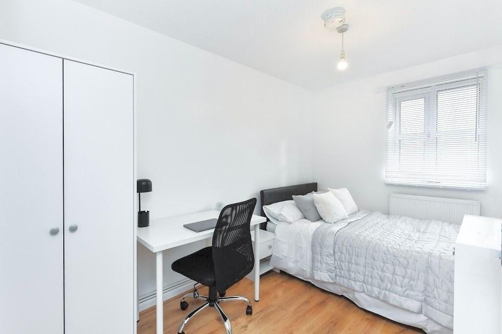 Bright and modern bedroom featuring a neatly ma...