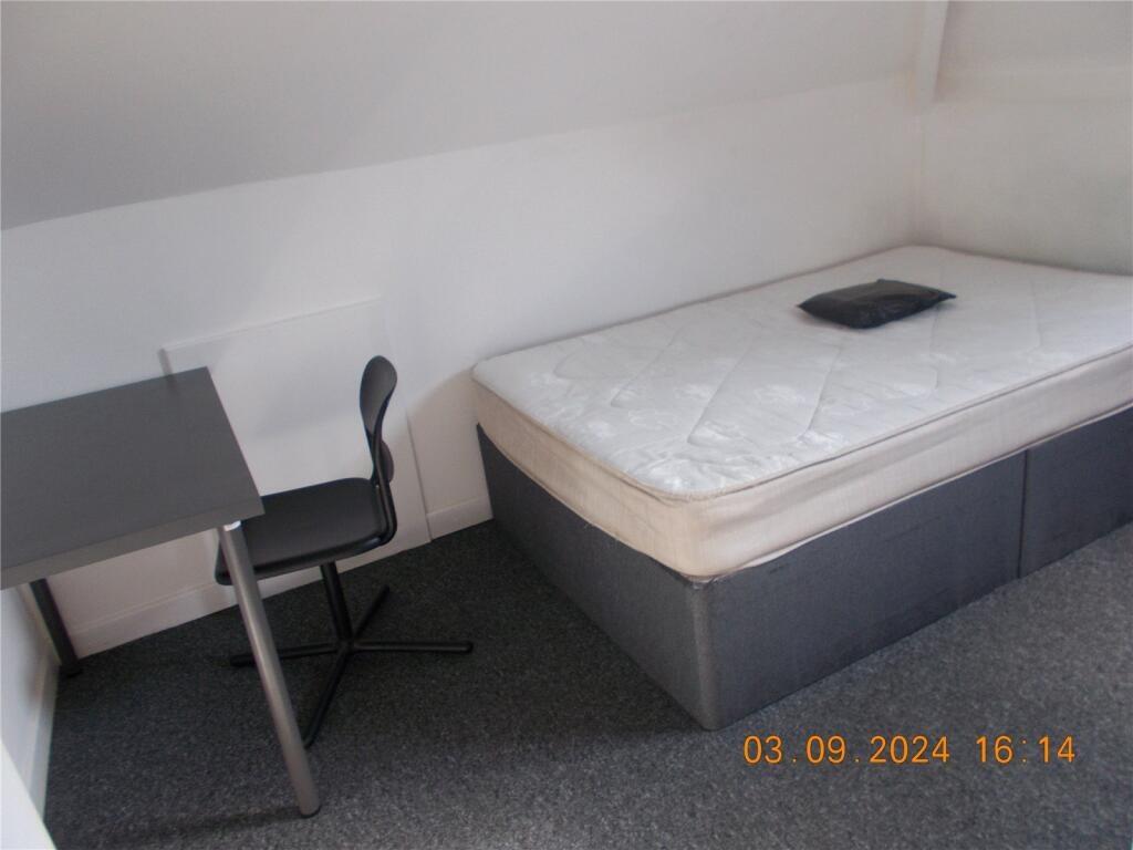 A neat and simple single bedroom featuring a ma...