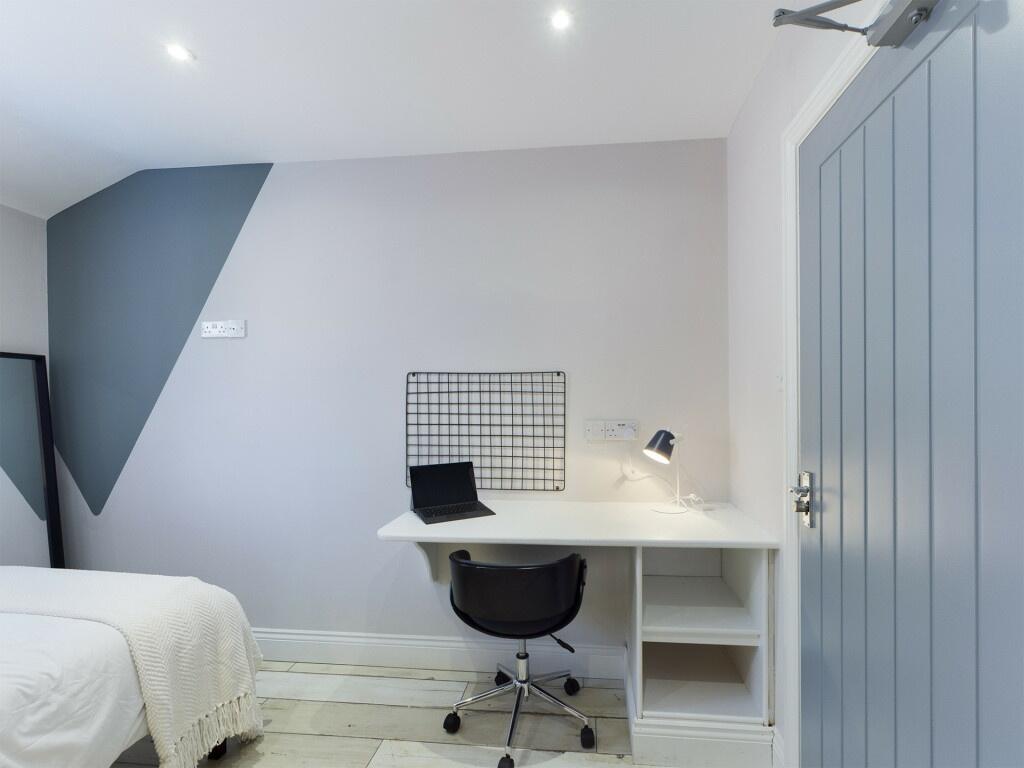 A bright and clean bedroom featuring a simple d...