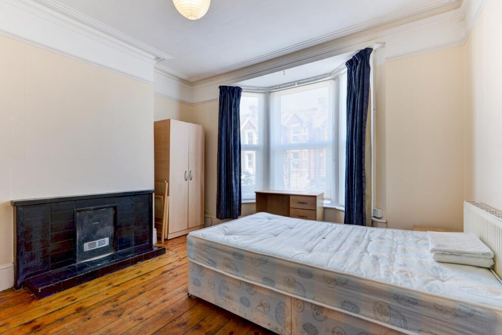 A bright double bedroom featuring a large bay w...