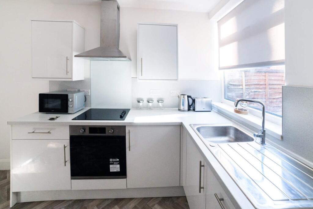 Modern kitchen featuring sleek cabinetry, ample...