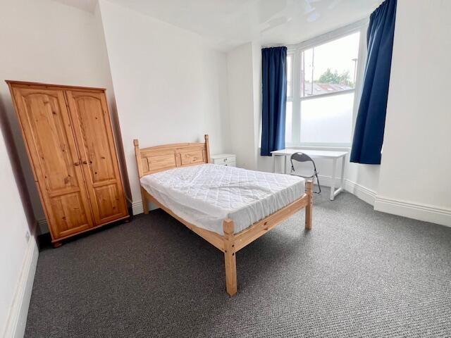 Bright and airy double bedroom featuring a wood...
