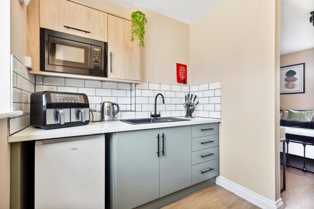 This modern kitchen features sleek cabinetry, a...
