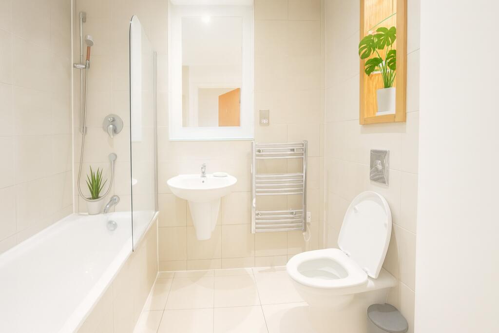 A bright and modern bathroom suite featuring a ...