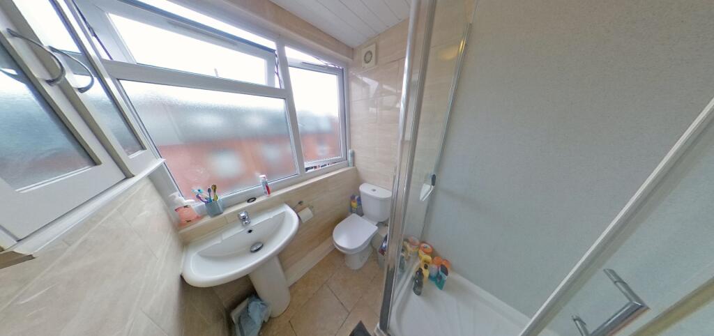 A bright and clean bathroom featuring a bathtub...