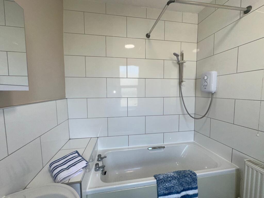 Bright and clean bathroom suite featuring a mod...