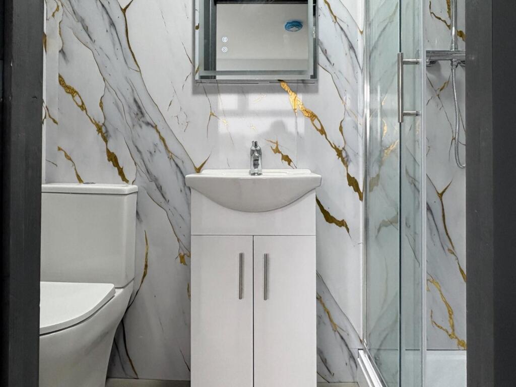 Contemporary bathroom with marble-effect wall t...