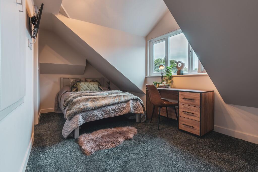 A cozy, well-maintained bedroom with a comforta...