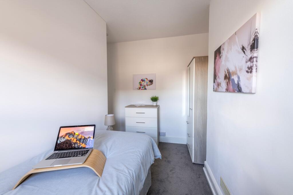 A bright and tidy bedroom featuring a single be...
