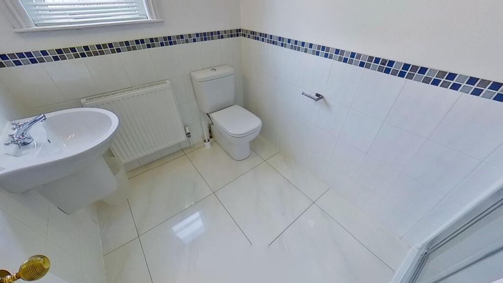 Bright, modern white tiled bathroom with a pede...