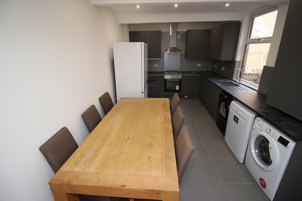 Modern kitchen with ample seating at a wooden d...