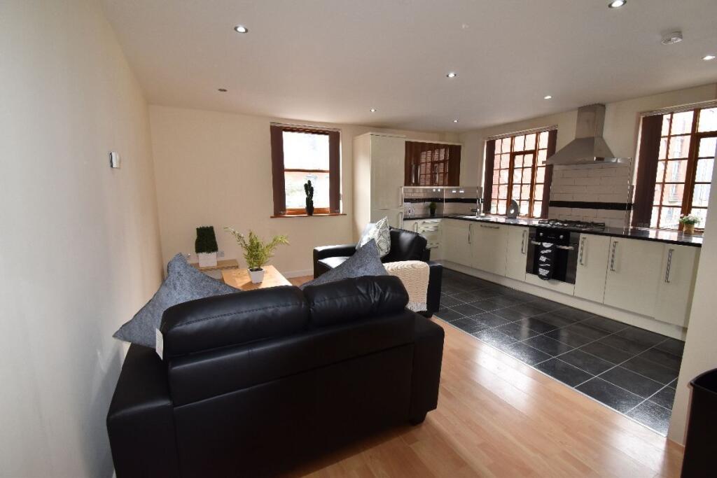 Bright and modern open-plan living room and kit...