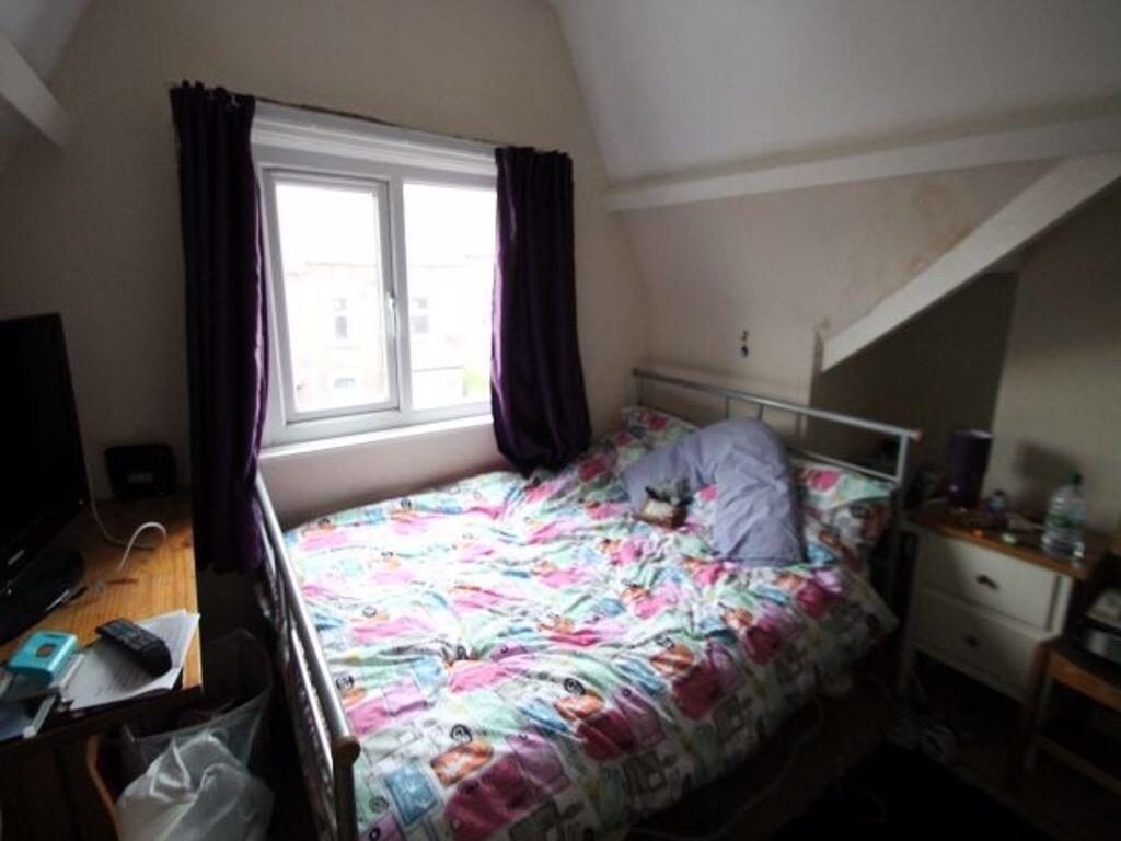 A spacious and bright bedroom featuring a doubl...