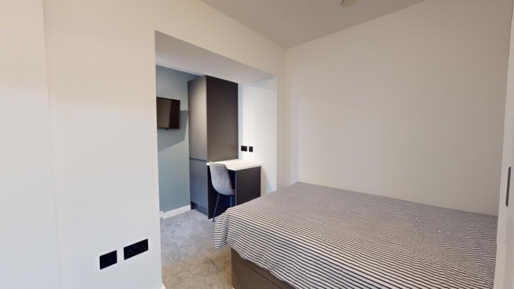A bright and tidy double bedroom featuring a co...