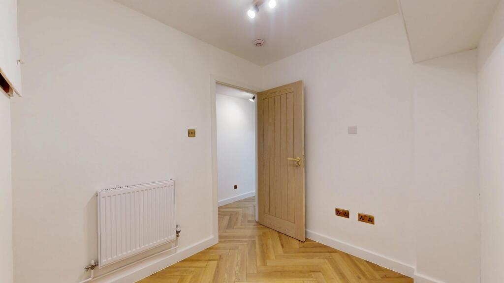 Bright and clean hallway featuring light wood f...