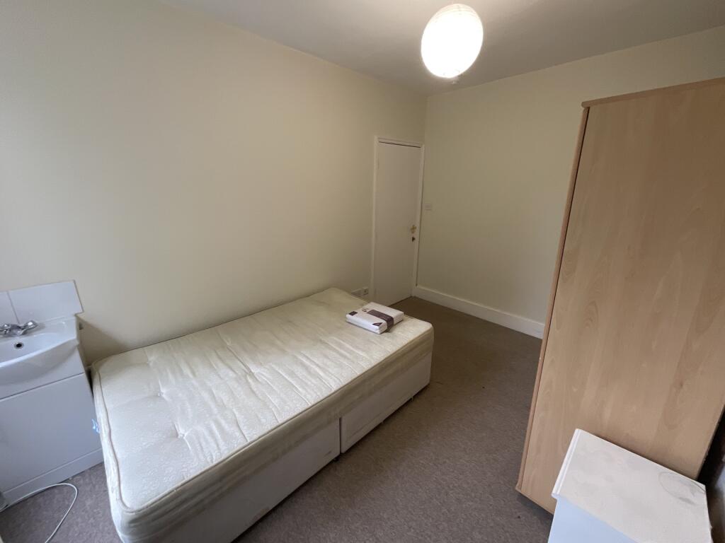 A simple, neat single bedroom featuring a clean...