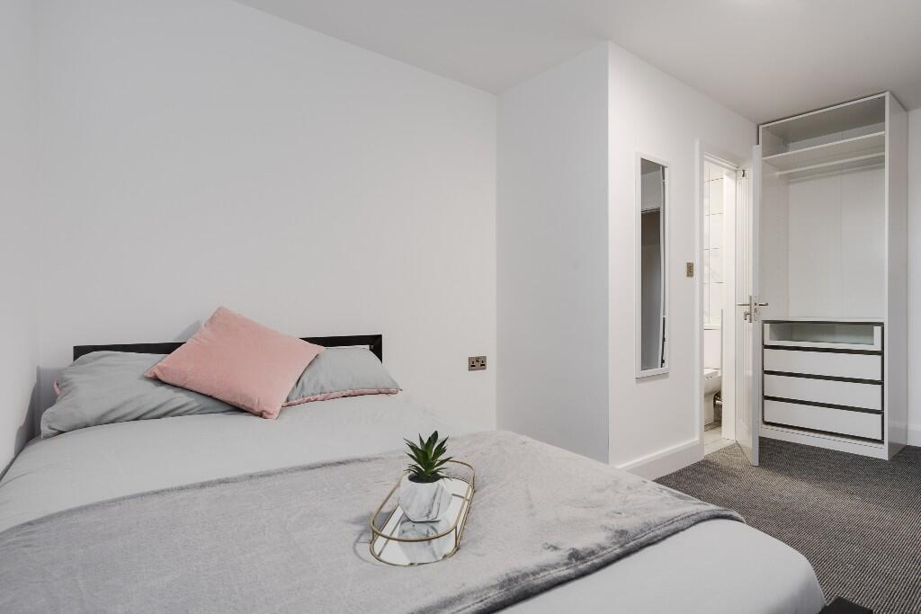 This cozy double bedroom features a comfortable...
