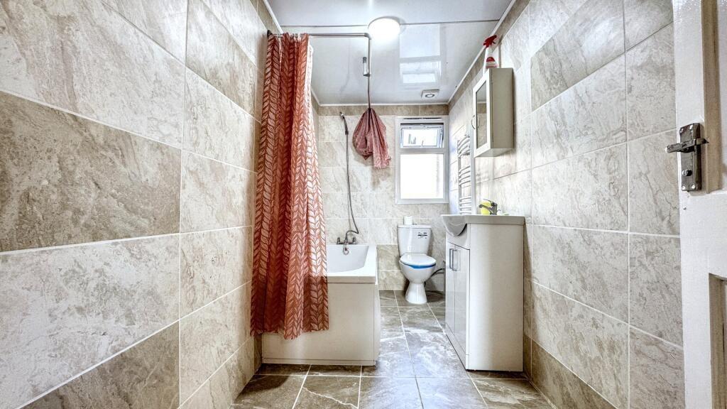 Bright and modern bathroom featuring stylish ti...