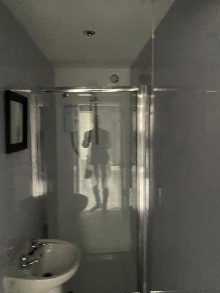 A compact bathroom featuring a clean sink and a...