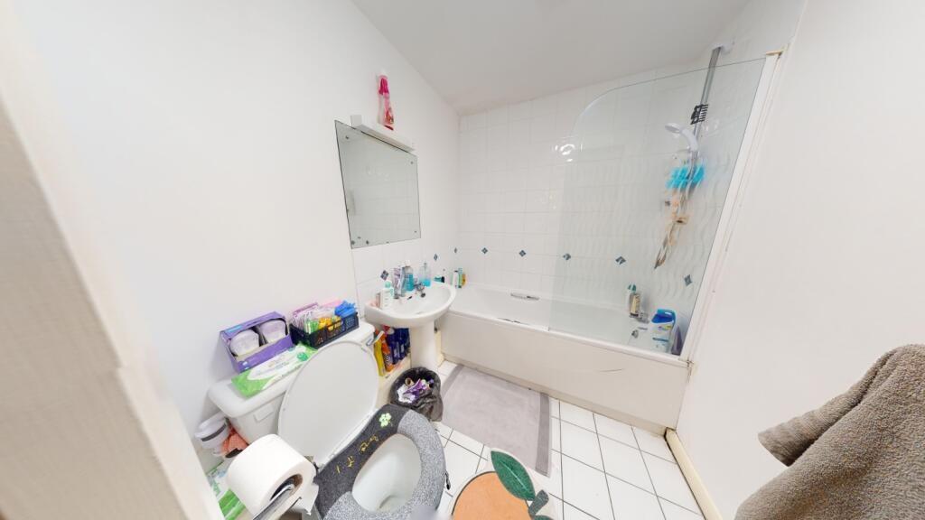 A bright bathroom suite featuring a full bathtu...