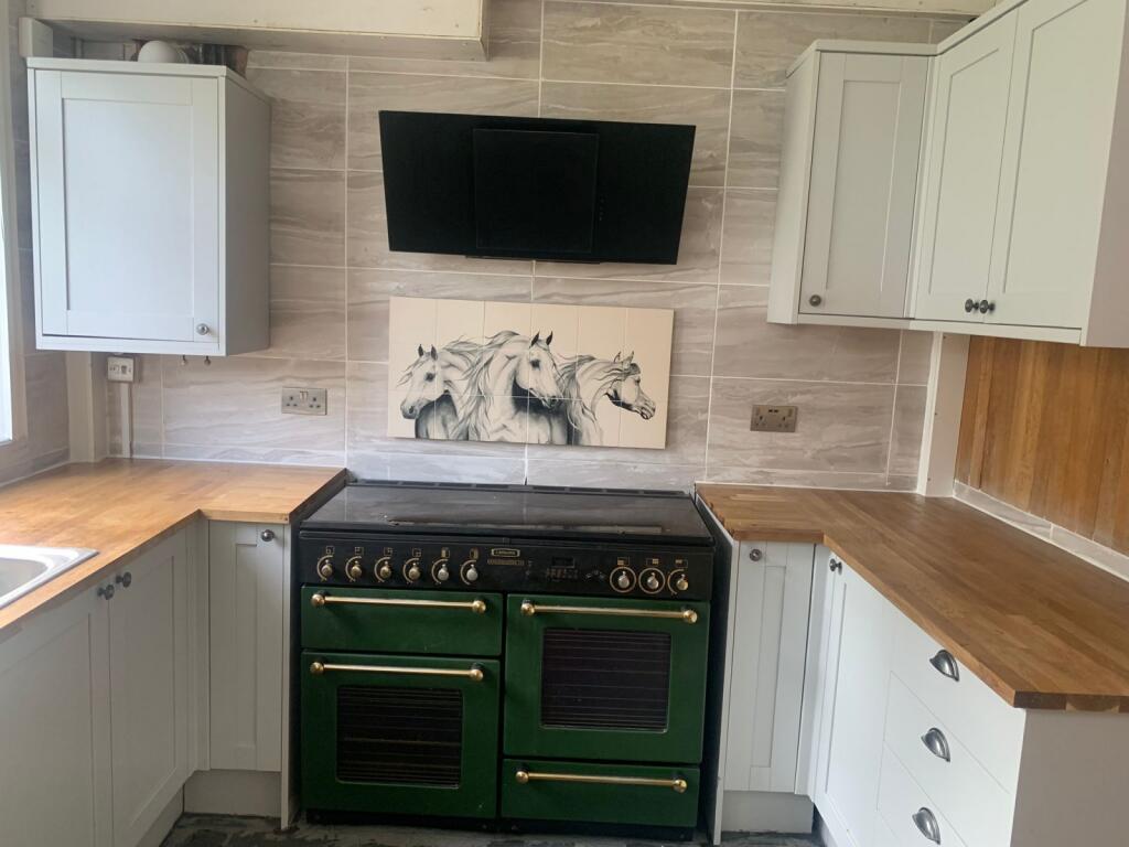 A stylish kitchen featuring a classic green ove...