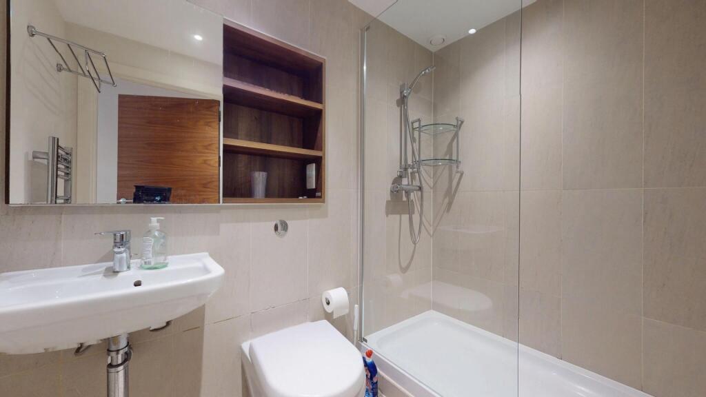 Modern bathroom suite featuring a clean white s...