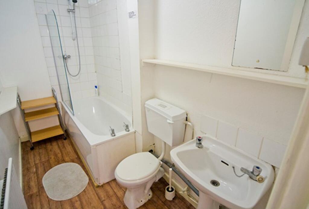 A well-maintained bathroom featuring a bath and...