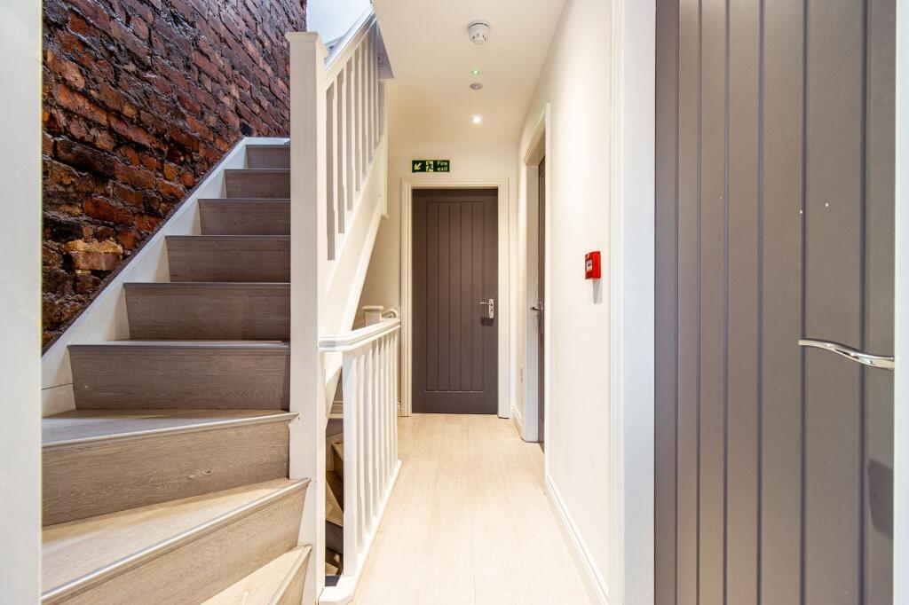 Bright, modern hallway with light wood floors, ...