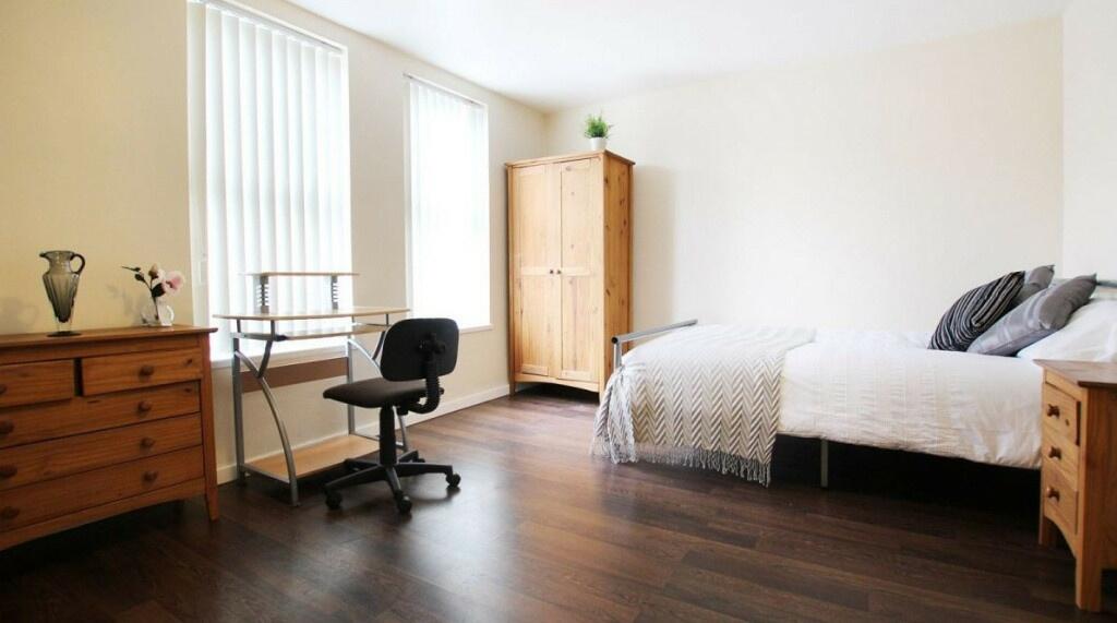A bright and spacious master bedroom with a lar...