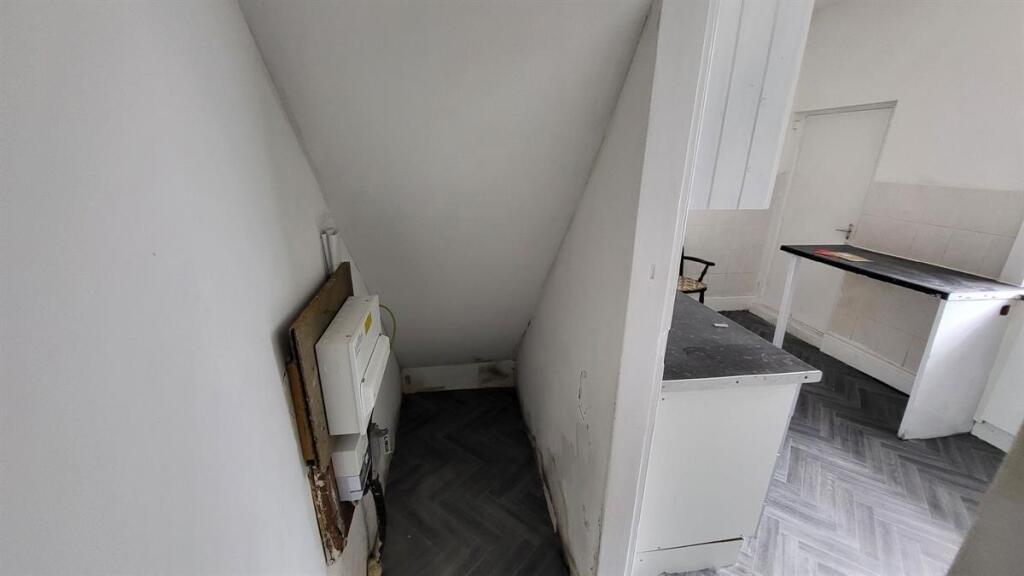 Narrow hallway with herringbone-style flooring ...