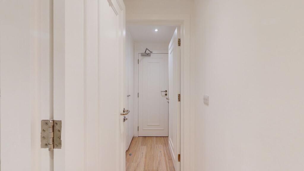 A clean and bright hallway with crisp white wal...