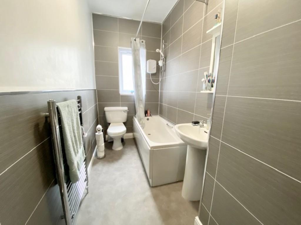 A modern, clean bathroom suite featuring a bath...
