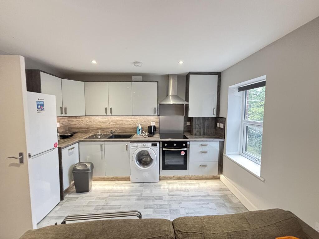Bright open-plan kitchen with modern white cabi...