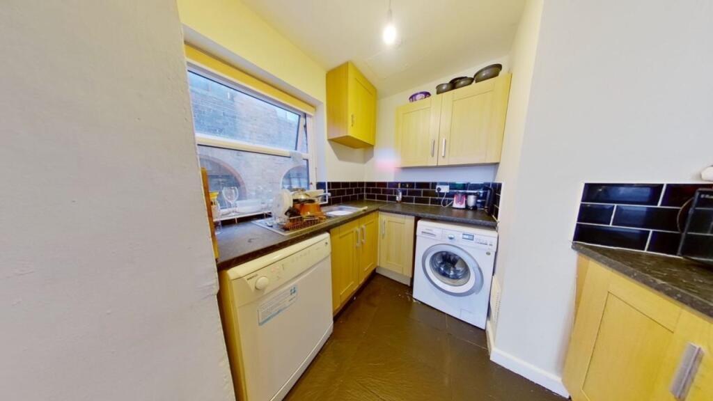 A neat and well-equipped kitchen featuring ligh...