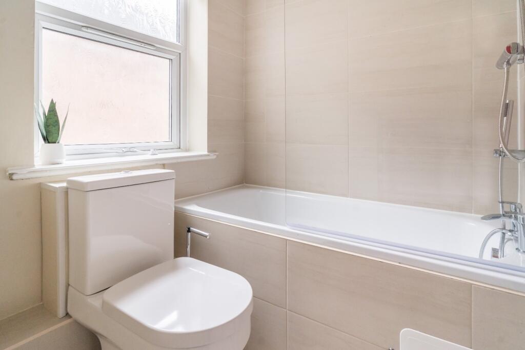 This modern bathroom features a sleek bathtub a...