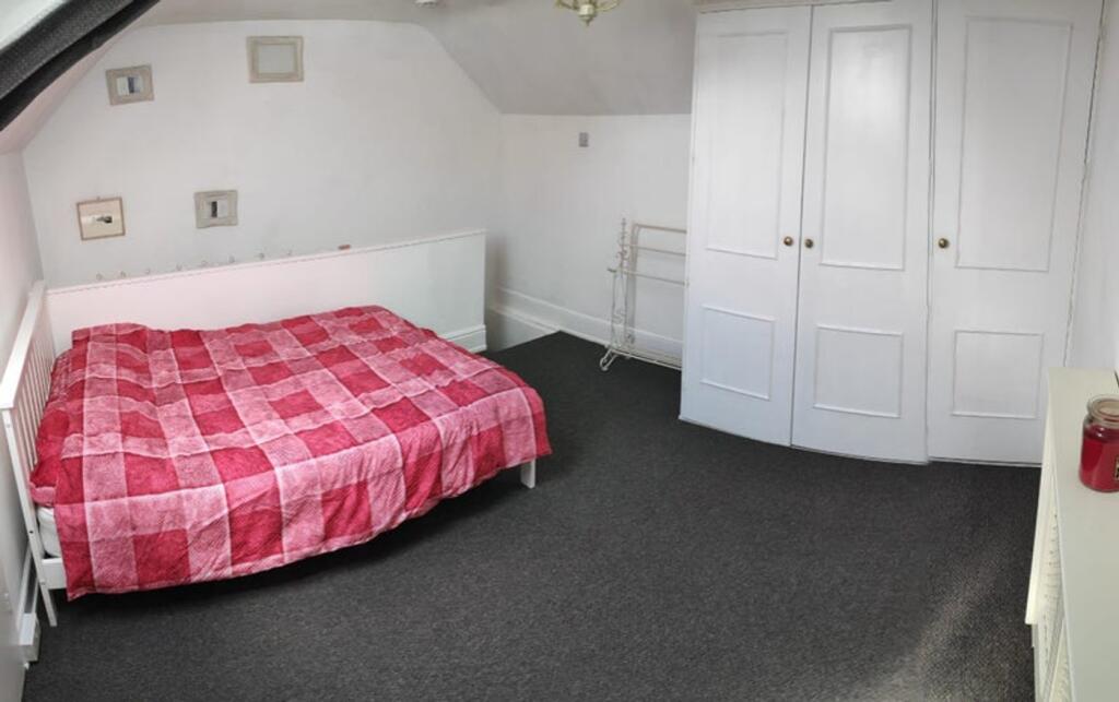 A tidy double bedroom featuring a red checkered...