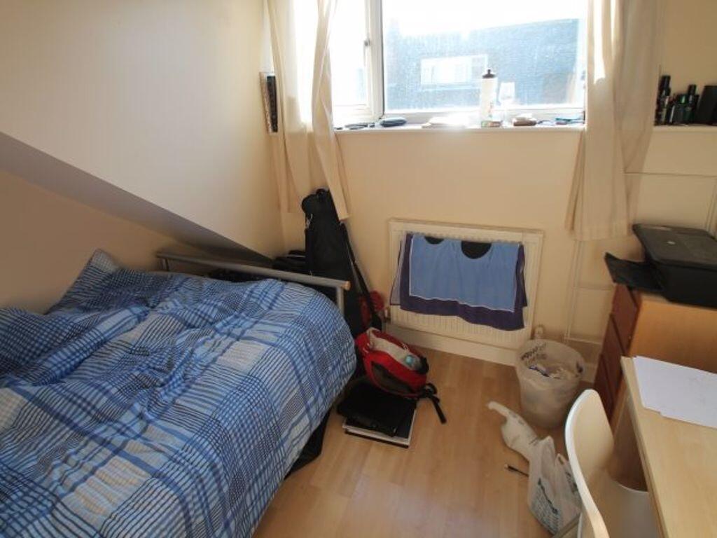Cozy single bedroom featuring a neatly made bed...