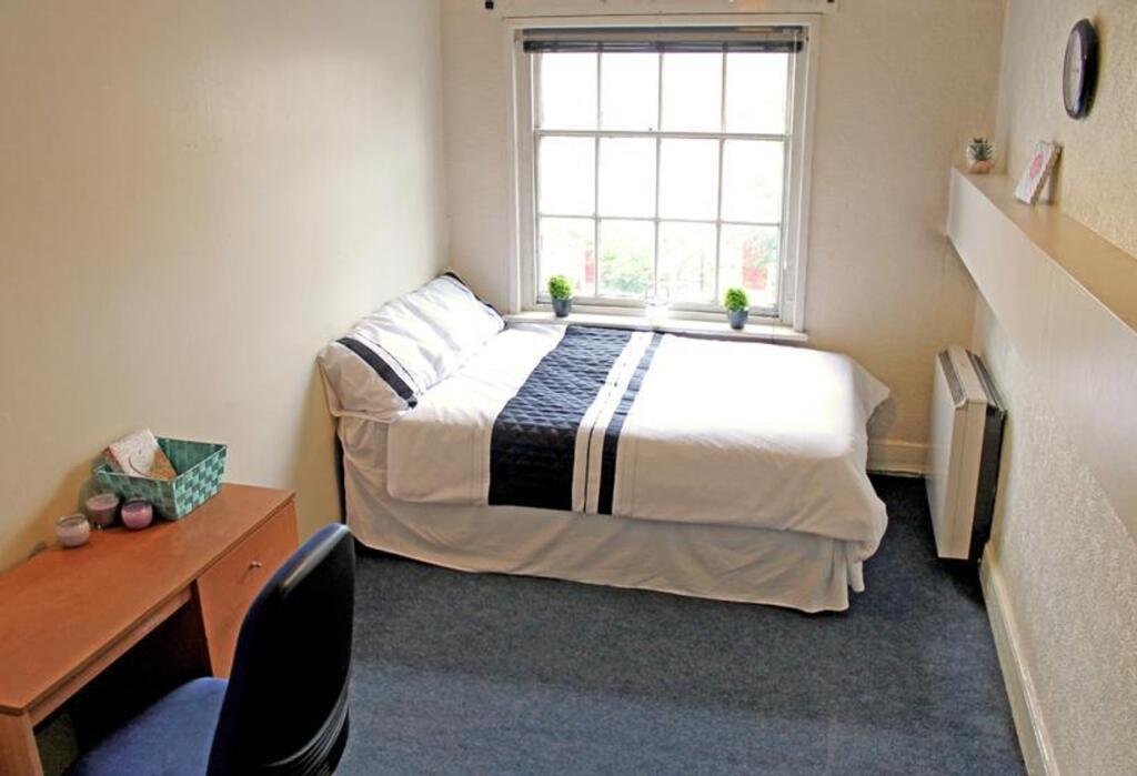 This inviting double bedroom features a cozy la...