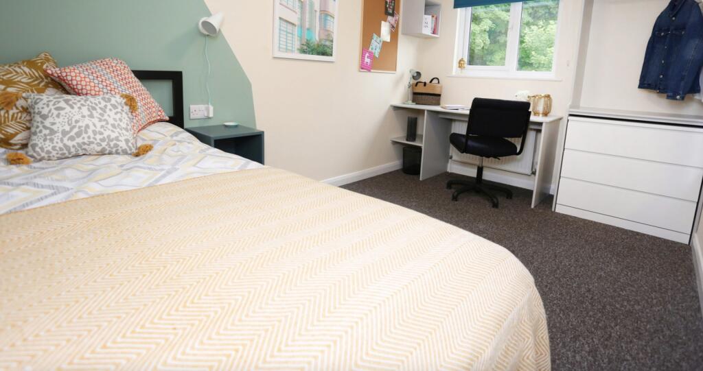 This inviting double bedroom features a cozy la...