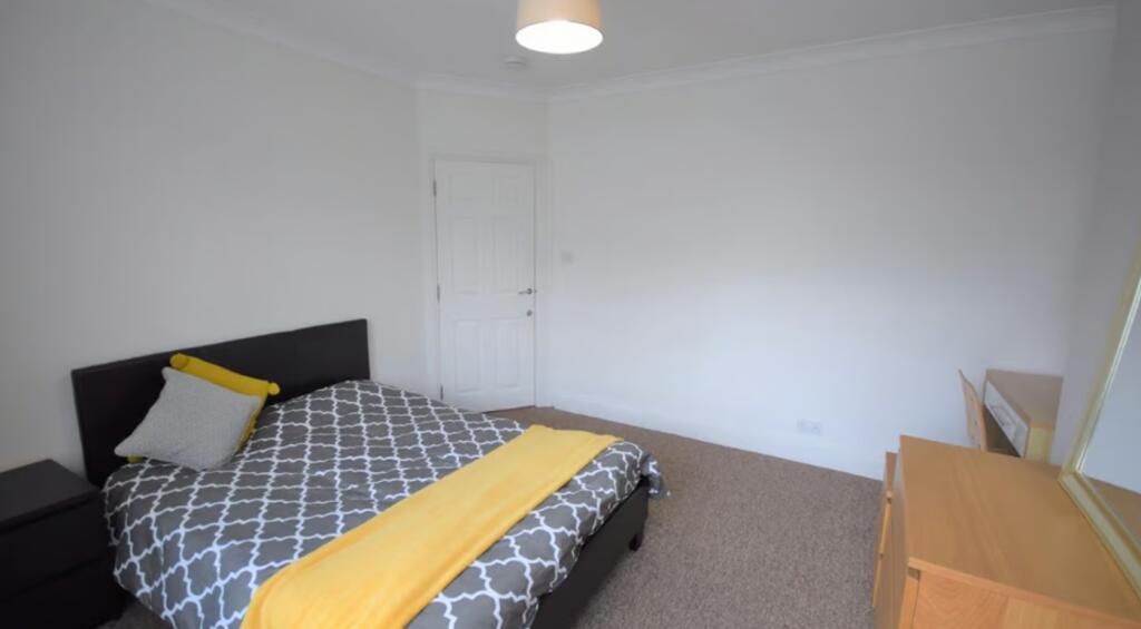 This cozy double bedroom features a comfortable...