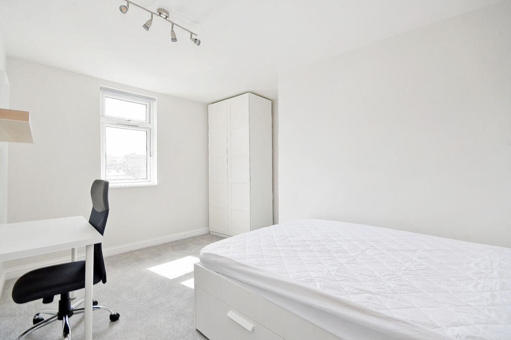 Bright, spacious master bedroom with a large be...