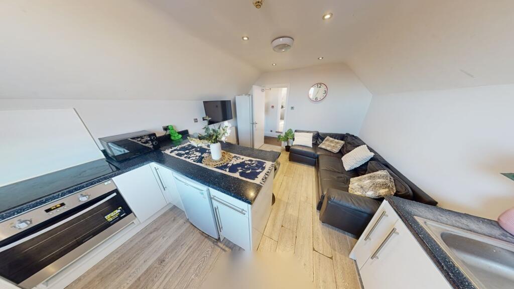 A modern, open-plan living room and kitchen are...